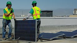 Workers installing panels on KQED roof