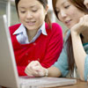 Two women using laptop