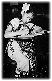 young Chinese girl sitting at a school desk